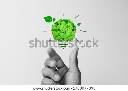 Corporate Social Responsibility (CSR), eco-friendly business concepts with businessman hand holding crumpled green paper light bulb