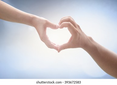 Corporate Social Responsibility (CSR) Concept: Two Human Hands Forming In Shape Of Heart Over Blurred Nature Background