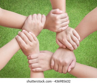 Corporate Social Responsibility CSR On Children's Friendship Education, Teamwork Empowerment Community Concept With Kids And Friends Holding Hands Together Isolated On Green Lawn Background