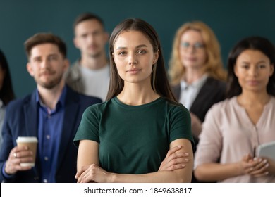 Corporate Spirit. Portrait Of Happy Millennial Woman New Employee Worker Intern Looking At Camera Starting Career Having Confidence In Future Proud Glad Of Feeling Part Of Big Diverse Multiethnic Team