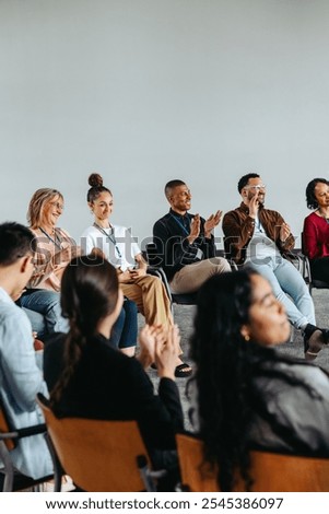 Corporate team engaging in an interactive workshop. A diverse group clapping during a meeting, highlighting teamwork and collaboration.