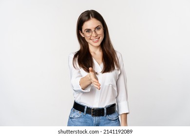 Corporate woman in office extending hand and smiling, handshake, greeting business partner, standing in glasses over white background