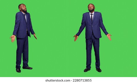 Corporate worker saying i dont know on camera and standing over full body greenscreen backdrop. Young startup employee in suit feeling unsure and confused, being uncertain in studio. - Powered by Shutterstock