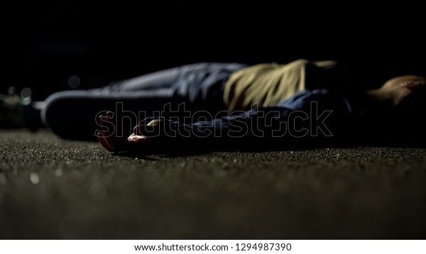 Corpse of female victim lying on ground at
parking lot, terrible road
accident