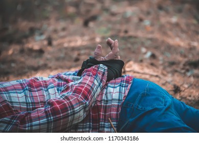the corpse of a man with bound hands in the forest.