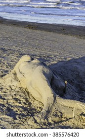 CORPUS CHRISTI, TEXAS/USA - FEBRUARY 26, 2016: A Graceful Sand Sculpture Of A Mermaid (by An Unidentified Artist) Seems Almost To Have Been Washed Ashore Along The Beach Near Sunset On Padre Island.