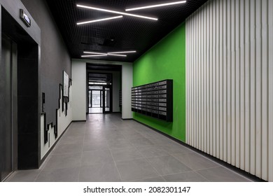 Corridor hall interior, with front door and elevator in many apartment building, with mailboxes with green walls