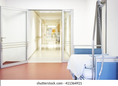 Corridor In Hospital With Bed And Open Door Deserted