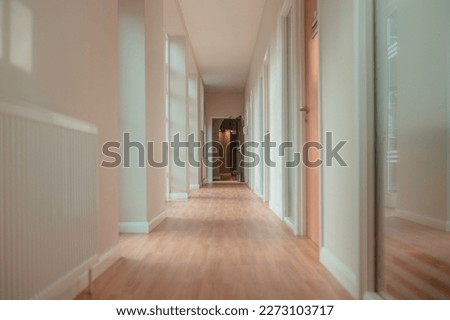 Corridor inside a doctor's surgery, clinic, dental practice or therapy centre. Light interior, hallway with doors and large windows. 