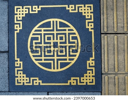 Corridor on Thalang Road with black tiles with beautiful golden Chinese patterns. This pattern can be seen on walking paths in the old town Mueang Phuket District, Thailand.
