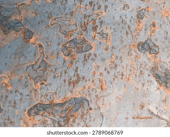 Corroded metal texture with rust bubbles and orange patterns. Abstract rust surface on blue gray steel showing organic corrosion shapes and rough metal detail for industrial background.
