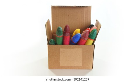 Corrugated cardboard box open with crayons inside on white background - Front view