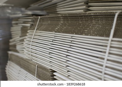 Corrugated cardboard sheets are one by one, they are prepared for the production of cardboard boxes. Polygraphic background of cardboard