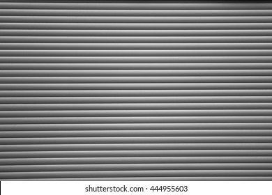 A corrugated fence of silver metal sheets with screw. Texture of metal fence