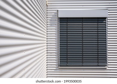 Corrugated Iron Facade Of A Warehouse. Window With Closed Blinds