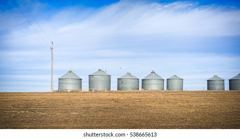 Corrugated Steel Silos in a Row with Cloudy, Blue Sky and Dry Grass - North Dakota