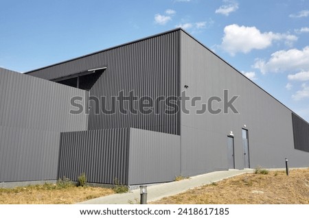 Corrugated steel warehouse or factory industrial building against blue sky. Architecture. Metal texture