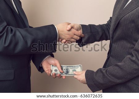 Corrupted businessman sealing the deal with a handshake and receiving a bribe money