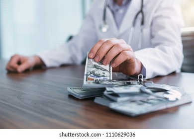 Corrupted Healthcare. Successful Skilled Doctor Sitting At The Table And Taking Bribes