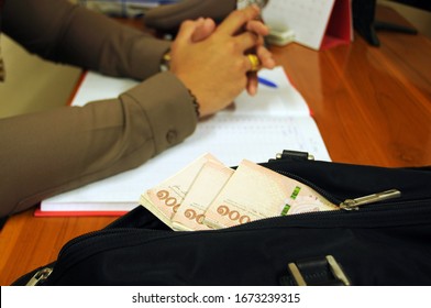 Corruption Concept.- 1,000 Thailand bath banknotes in a black bag on the table for government officer.