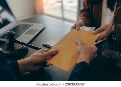 Corruption Concept, Government officials are accepting corruption payments that businessmen deliver.Politician hands taking bribe money under office table, lobbying of interests - Shutterstock ID 2380833989
