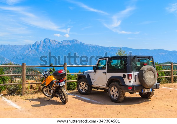CORSICA\
ISLAND, FRANCE - JUN 27, 2015: motorcycle and Jeep Wrangler parking\
in mountain landscape of Corsica island. France is the second most\
visited country in Europe, first is\
Italy.