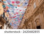 Corso Vittorio Emanuele in the historic UNESCO World Heritage city of Noto, Sicily, Italy, with colorful crocheted parasols