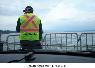 Cortes Island, Canada - July 6, 2020: BC Ferries safety attendant wearing a face mask on a ferry from Cortes Island to Quadra Island.