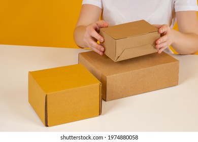 Corton boxes symbolize fulfillment process. Concept - fulfillment service for online store. Fulfillment center employee processes order. Boxes in female hands close up. Preparing goods for shipment Corton boxes symbolize fulfillment process. Concept - fulfillment service for online store. Fulfillment center employee processes order. Boxes in female hands close up. Preparing goods for shipment