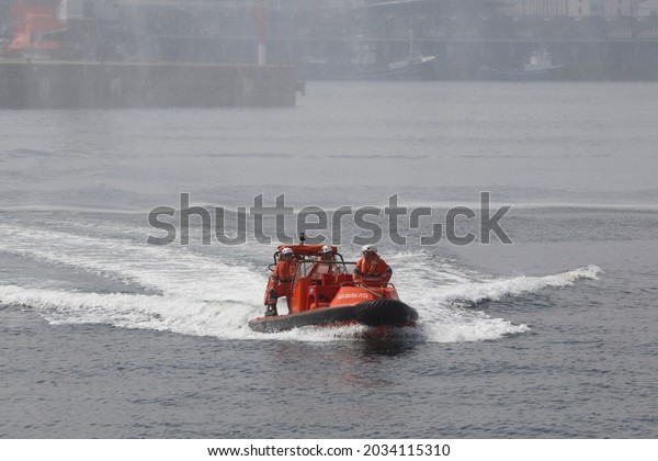 Coruna-Spain.Small maritime\
rescue boat with several rescuers making gestures during a rescue\
on August 28,\
2021