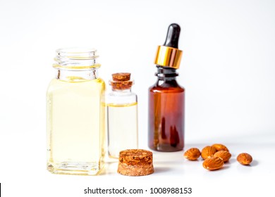 cosmetic almond oil in glass bottle on white background