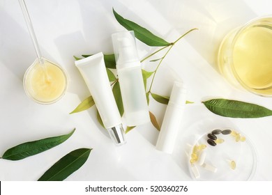 Cosmetic bottle containers with green herbal leaves, Blank label for branding mock-up, Natural beauty product concept. - Shutterstock ID 520360276