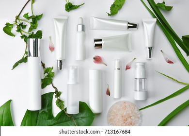 Cosmetic bottle containers with green herbal leaves, Blank label package for branding mock-up, Natural organic beauty product concept. - Shutterstock ID 713167684