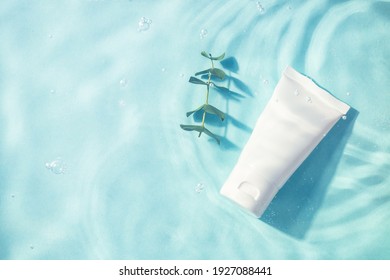 Cosmetic bottle and green leaves under water. Moisturizing, reparing and skincare product.