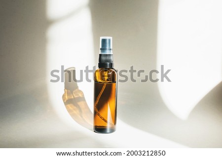 Cosmetic bottle made of dark amber glass on a white background with a shadow. Close-up, copy space. Beauty blogs, the concept of salon treatment, the layout of the brand's packaging in the style of