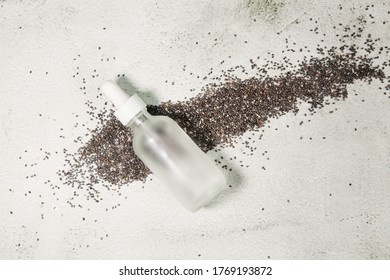 Cosmetic Bottle With Pipette And Chia Seed Oil On Gray Background.