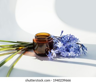 cosmetic or candle, amber jar or
 glass bottles with blue flower, isolated white background. Close up, minimal brand packaging mock up, can also be used for honey or hazelnut, peanut butter.