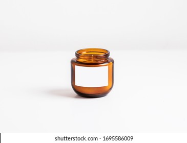 cosmetic or candle, dark amber glass bottles, isolated white background. Closeup, minimal brand packaging mock up,
can also be used for honey or hazelnut, peanut butter.