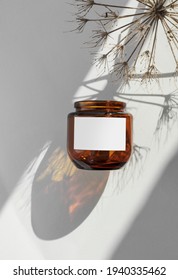 cosmetic or candle, labeled amber jar
 glass bottles. Sunny, minimal white background. Close up, minimal brand packaging mock up, can also be used for honey or hazelnut, peanut butter.