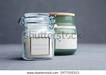 
cosmetic or candles, green glass bottles with lids and eucalyptus messages. Close-up, minimalist branded packaging mockup