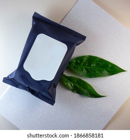 Cosmetic Cleaning Wipes. Black Package Without A Label On It.  Mock Up For Napkin. Cleansing Tissues. Makeup Remover.Green Leaf Like Decoration For A Nice Composition.
