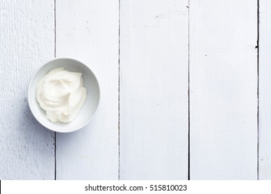 Cosmetic Cream At China Bowl On White Wood Table Background