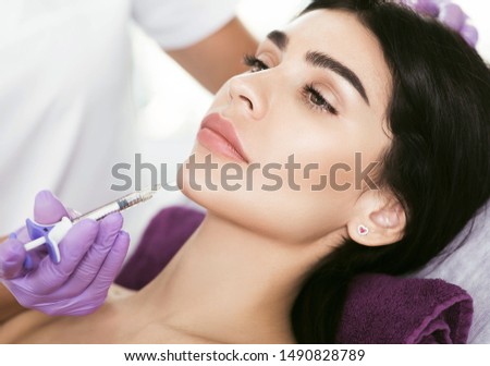 Cosmetic face treatment. Beautiful mid aged woman getting face injection, lifting effect, beauty injections for face lift and tighten face contour