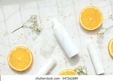 Cosmetic foam pump bottle containers with fresh orange slices, Blank label for branding mock-up, Natural beauty product concept.