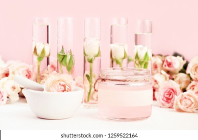Cosmetic glass jar of natural herbal beauty product for skin & body care. Delicate roses and soft pink tones. Botanical spa treatment.
