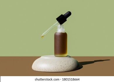 Cosmetic herbal, hemp oil bottle with dropper removed on stone pedestal. Poster, mockup, banner. Brown grassy colors. Frosted vial with moisturizing emulsion, serum. Natural skin hydration, body care