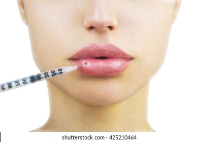 Cosmetic injection in the lower lip of unrecognizable woman, close-up. Beautiful big lips. Plastic and aesthetic surgery