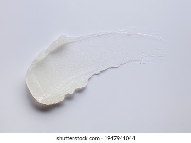 Cosmetic lip balm, salt or sugar scrub swatch on gray background