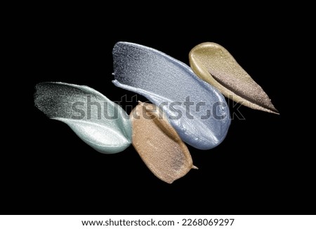 Cosmetic liquid gray beige gold shimmer texture eye shadow or high lighter isolated on black