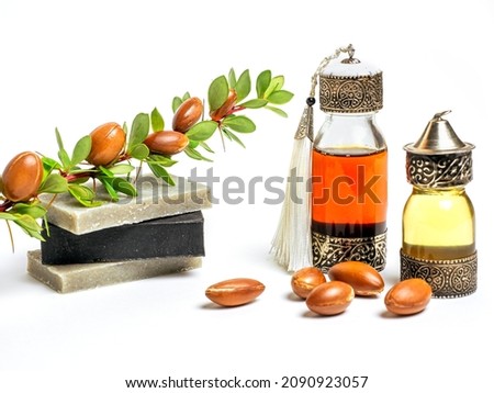 Cosmetic means: authentics oriental bottles with cosmetic oil, argan nuts and handmade soap.on isolated background. 